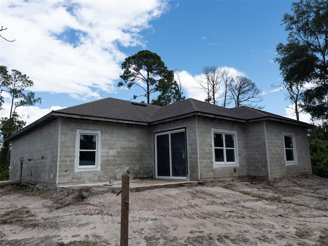 back of house featuring concrete block siding and a patio area