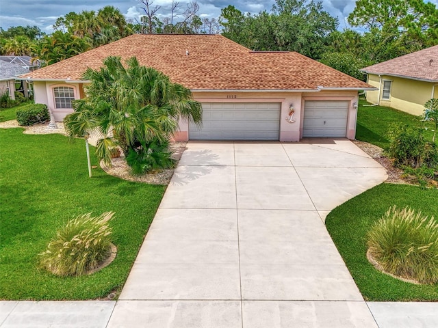 view of front of property featuring a front yard, a shingled roof, stucco siding, a garage, and driveway