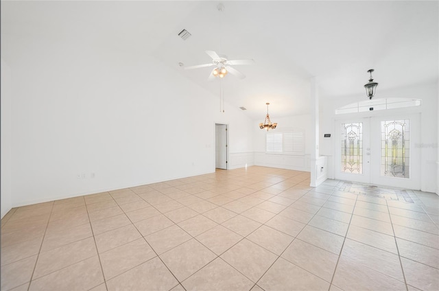 empty room featuring french doors, lofted ceiling, and light tile patterned floors