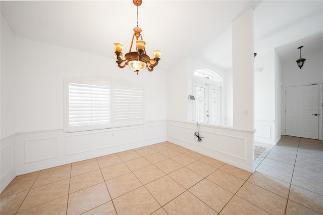 tiled spare room with a notable chandelier and plenty of natural light