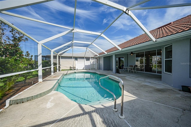 view of swimming pool with a patio area, a lanai, and ceiling fan