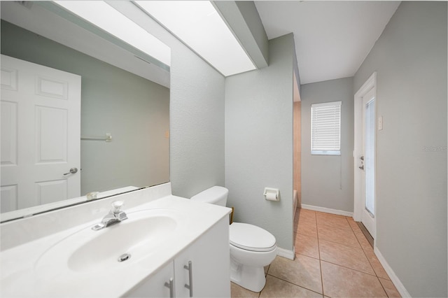 bathroom featuring vanity, tile patterned flooring, toilet, and baseboards