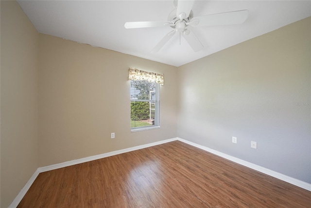 unfurnished room with wood finished floors, a ceiling fan, and baseboards