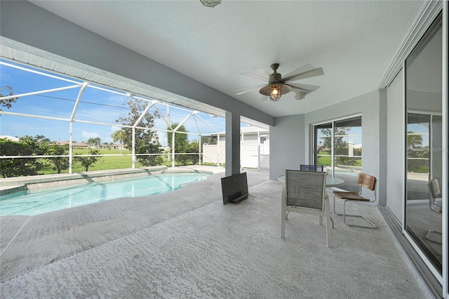 view of swimming pool with glass enclosure, ceiling fan, and a patio area