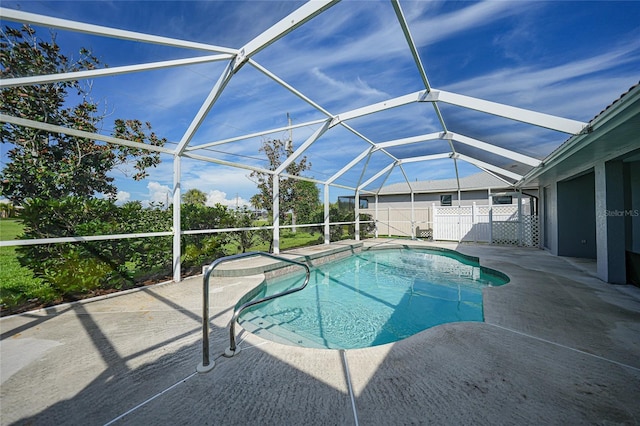 view of swimming pool featuring a lanai, a patio area, fence, and a fenced in pool