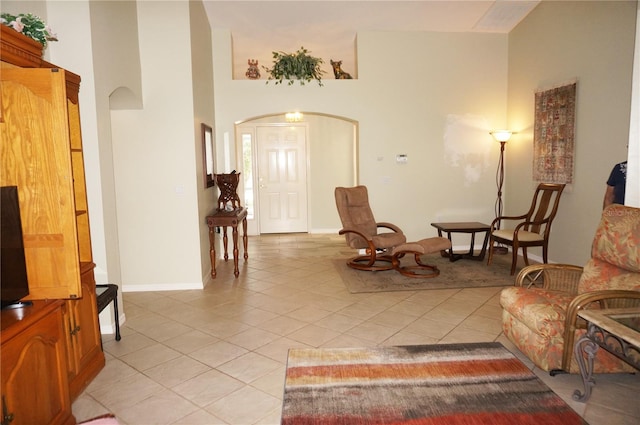 living area with light tile patterned floors and a high ceiling