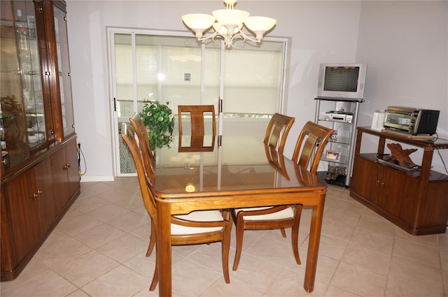 dining room with light tile patterned floors and an inviting chandelier