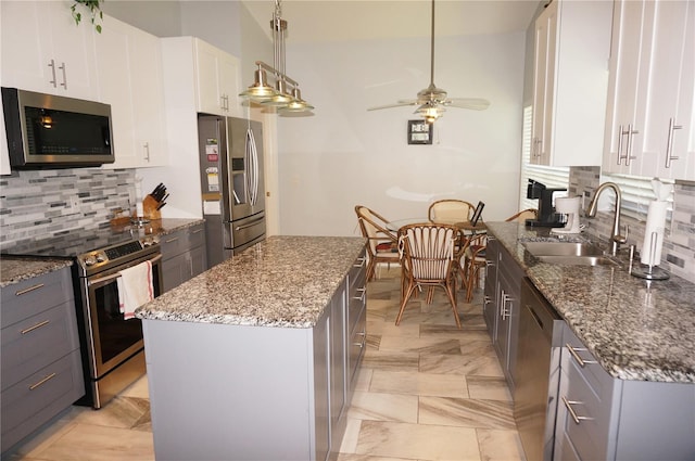 kitchen with decorative backsplash, appliances with stainless steel finishes, a center island, and light tile patterned floors