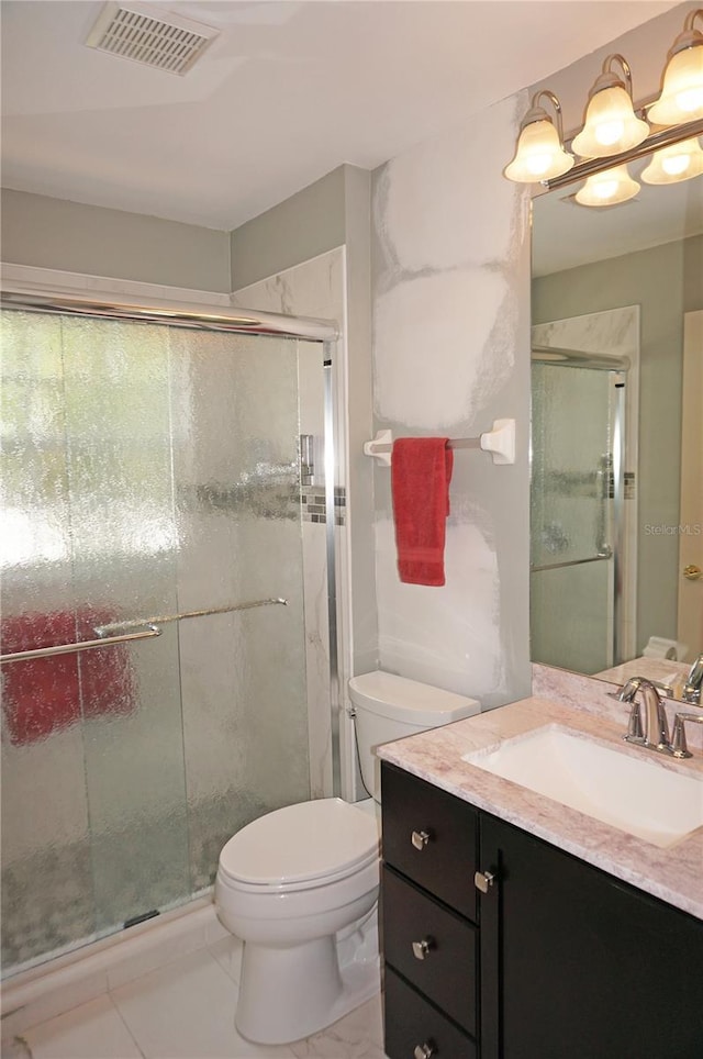 bathroom featuring toilet, vanity, and a shower with door