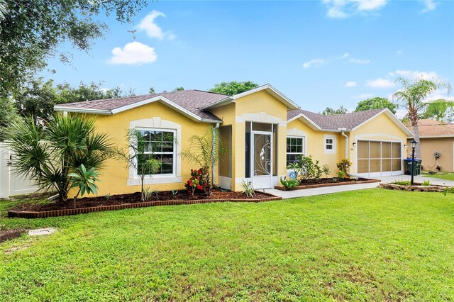 view of front of home featuring roof with shingles, stucco siding, a front yard, a garage, and driveway