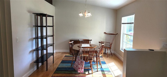 dining area featuring an inviting chandelier, baseboards, and wood finished floors