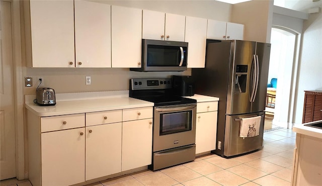 kitchen featuring appliances with stainless steel finishes, light countertops, white cabinetry, and light tile patterned floors