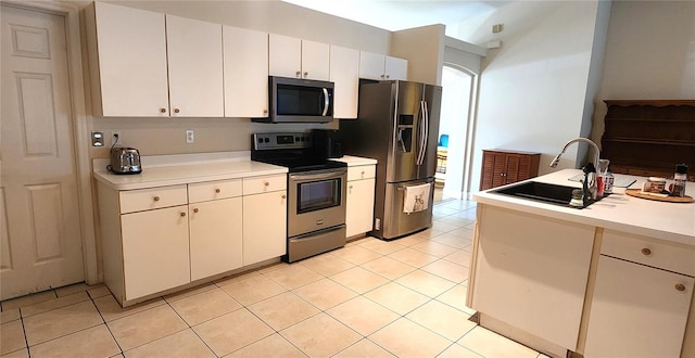 kitchen featuring light tile patterned floors, appliances with stainless steel finishes, light countertops, and a sink