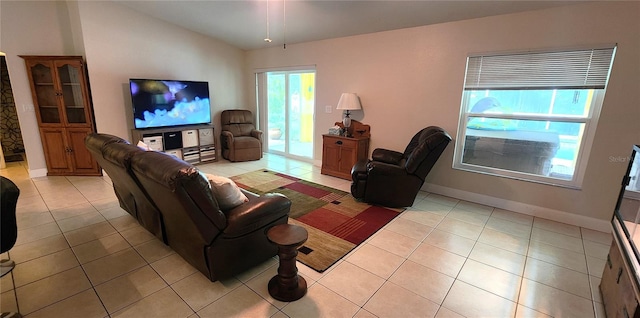 living room with light tile patterned floors, baseboards, and vaulted ceiling