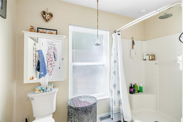 full bath featuring toilet and a tile shower