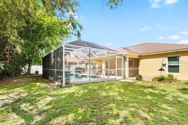 back of property with an outdoor pool, glass enclosure, a yard, a patio area, and stucco siding