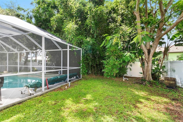 view of yard with glass enclosure, a fenced backyard, and a fenced in pool