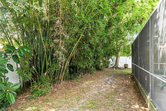 view of yard featuring fence and a lanai