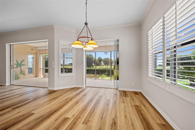 unfurnished dining area with a healthy amount of sunlight, light wood-type flooring, and ornamental molding