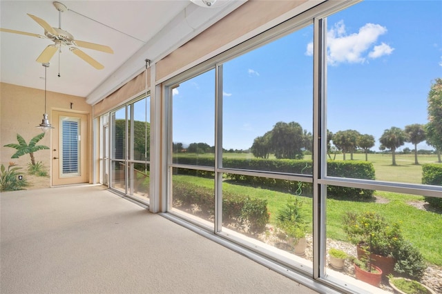 unfurnished sunroom featuring ceiling fan