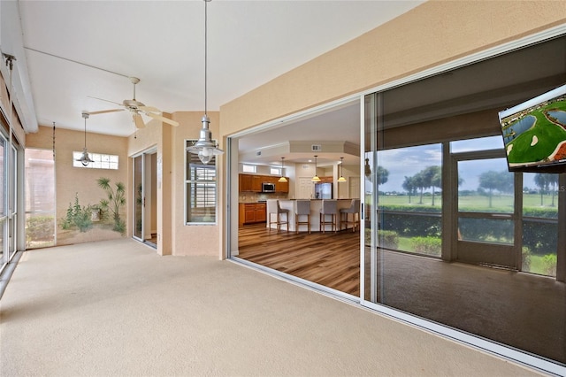 unfurnished sunroom with a healthy amount of sunlight and ceiling fan