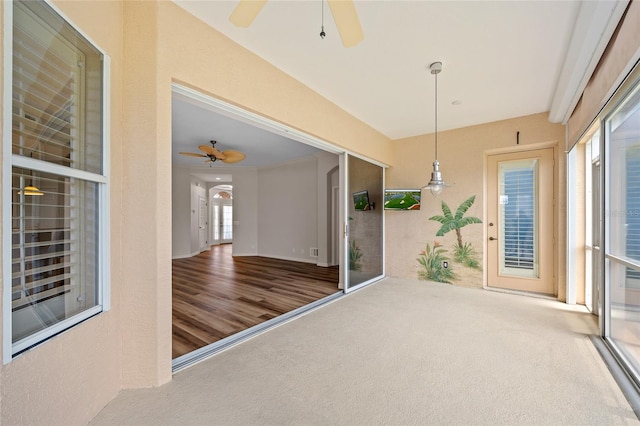 unfurnished sunroom with ceiling fan