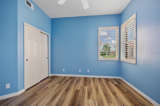 unfurnished bedroom featuring a closet, ceiling fan, and hardwood / wood-style floors