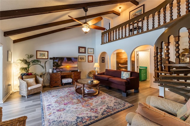 living room featuring high vaulted ceiling, ceiling fan, wood-type flooring, and beam ceiling