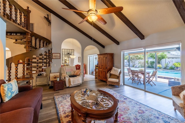 living room with high vaulted ceiling, ceiling fan, wood-type flooring, and beam ceiling