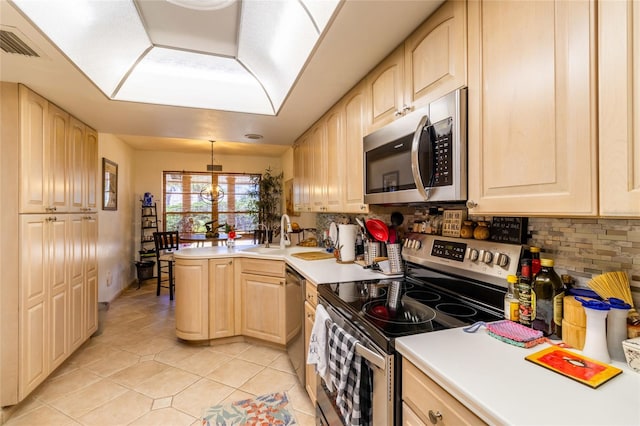 kitchen featuring pendant lighting, light brown cabinets, stainless steel appliances, and sink