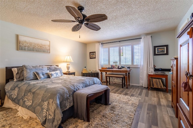 bedroom with a textured ceiling, ceiling fan, and dark hardwood / wood-style floors