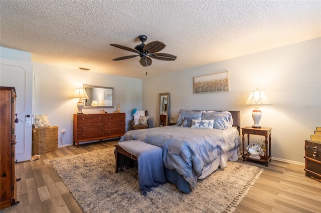 bedroom featuring a textured ceiling, light hardwood / wood-style flooring, and ceiling fan