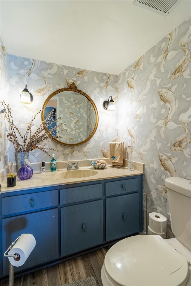 bathroom with vanity, toilet, and hardwood / wood-style floors