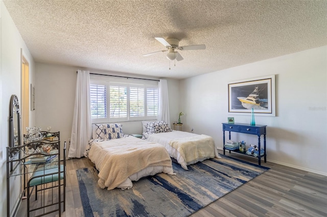 bedroom featuring a textured ceiling, dark wood-type flooring, and ceiling fan