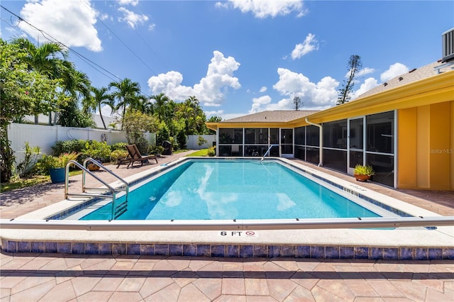 view of swimming pool with a patio area and a sunroom