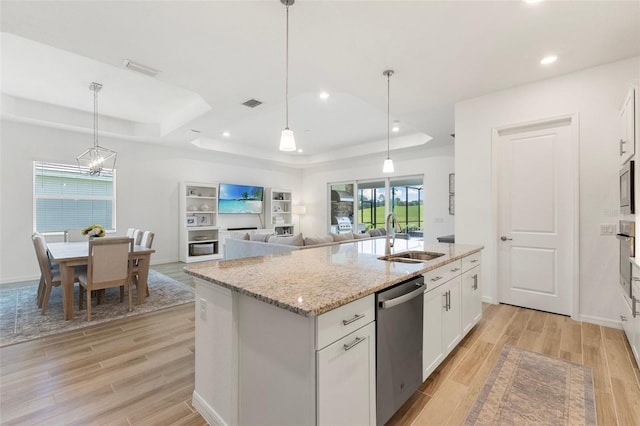 kitchen featuring light wood-type flooring, appliances with stainless steel finishes, sink, and a tray ceiling