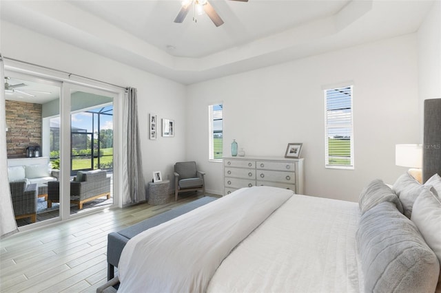 bedroom featuring access to outside, ceiling fan, and multiple windows