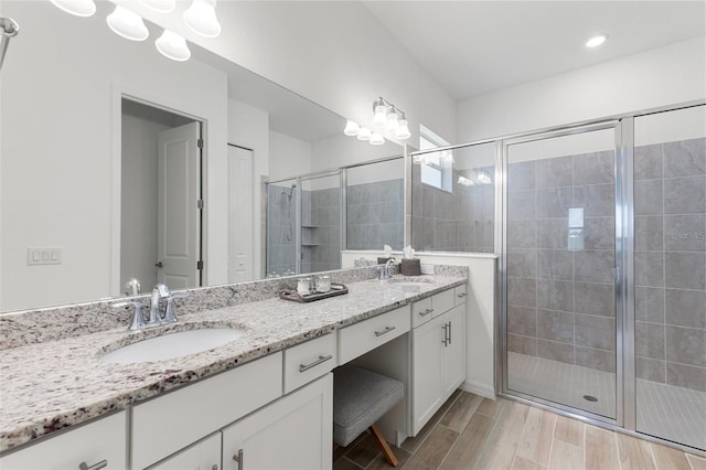 bathroom with double sink vanity and an enclosed shower