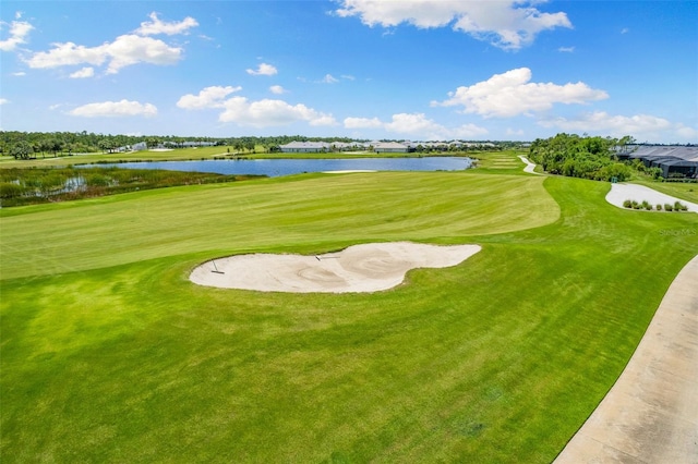 surrounding community with a water view and a lawn