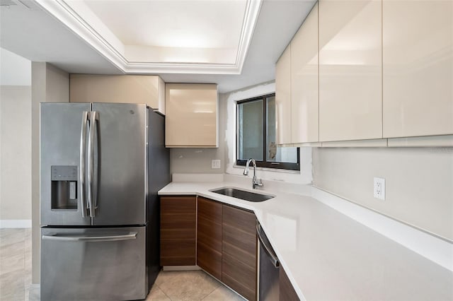 kitchen with dark brown cabinets, sink, light tile patterned floors, stainless steel refrigerator with ice dispenser, and a raised ceiling