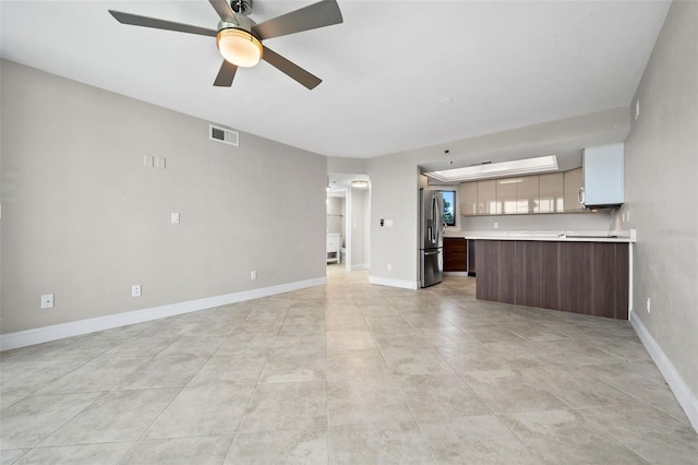 unfurnished living room featuring light tile patterned flooring and ceiling fan