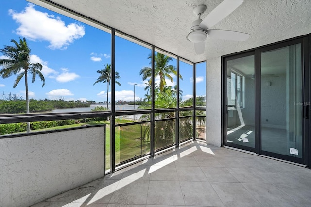 unfurnished sunroom featuring ceiling fan