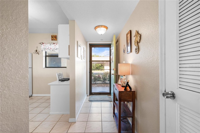 tiled entrance foyer featuring a textured ceiling