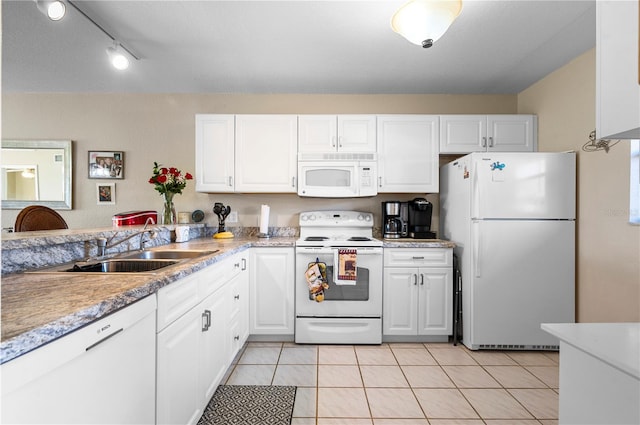 kitchen featuring light tile patterned flooring, white cabinets, track lighting, and white appliances