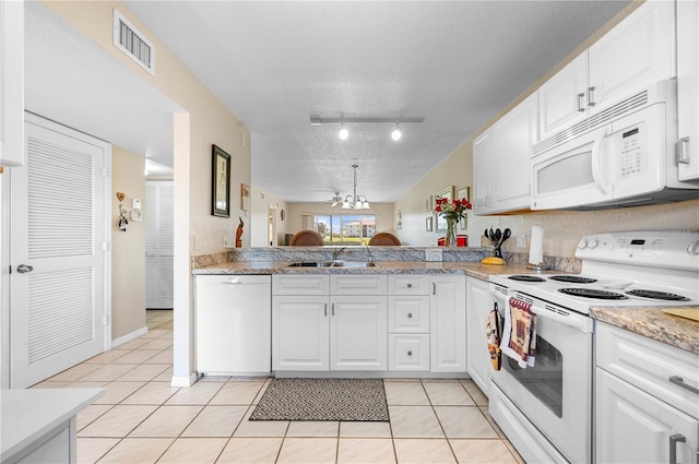 kitchen with white cabinets, track lighting, white appliances, and light tile patterned floors