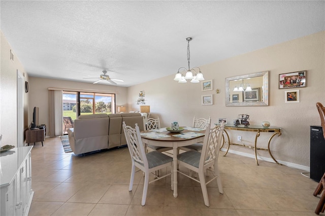 dining area with light tile patterned flooring, ceiling fan with notable chandelier, and a textured ceiling