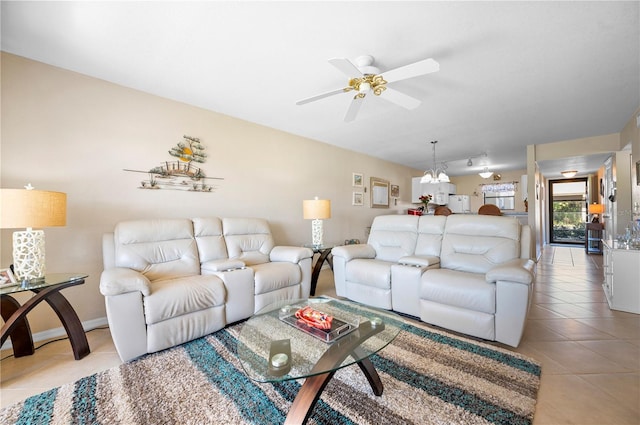 tiled living room with ceiling fan with notable chandelier