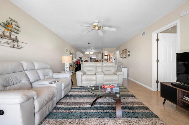 living room with ceiling fan with notable chandelier and light tile patterned floors