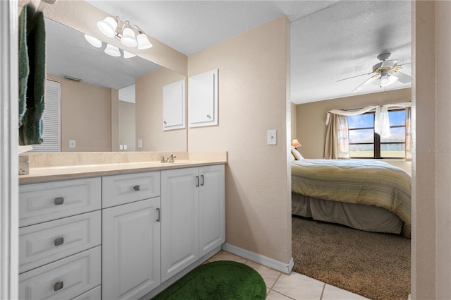 bathroom with ceiling fan with notable chandelier, tile patterned floors, vanity, and a textured ceiling