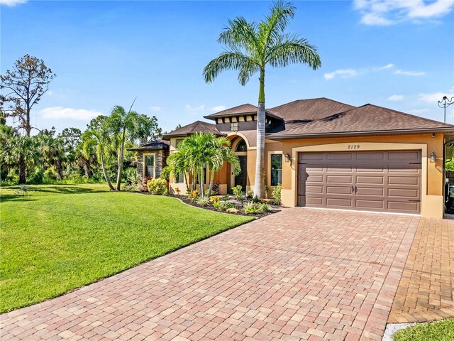 view of front of home featuring a garage, a front lawn, decorative driveway, and stucco siding